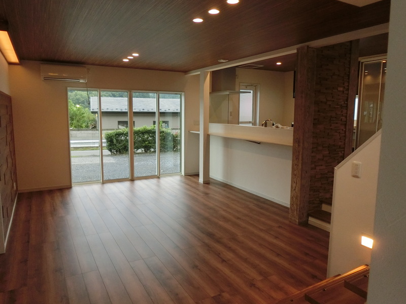 吐き出し窓を大きく取って、日当たりは最高。天井は木目調のクロスを張り、小上がりキッチンとの一体感を演出し、とても広く感じます。天気の良い日はそのままウッドデッキに出られるように作られています。